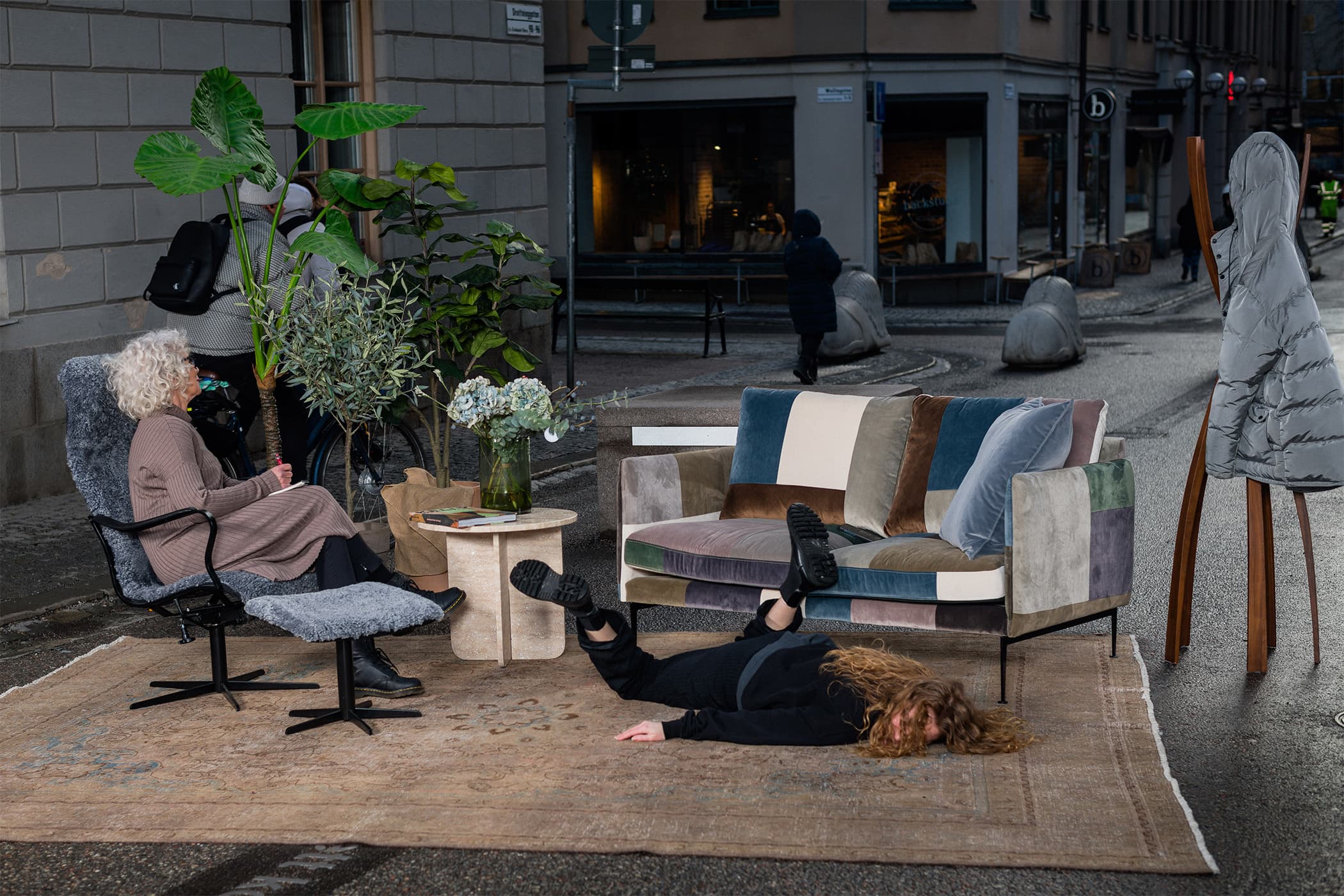 152cm bred dunsoffa med höga ryggkuddar och smala armstöd, klädd i en mönstrad tygblandning. Reclinerfåtölj i grå fårskinn. 