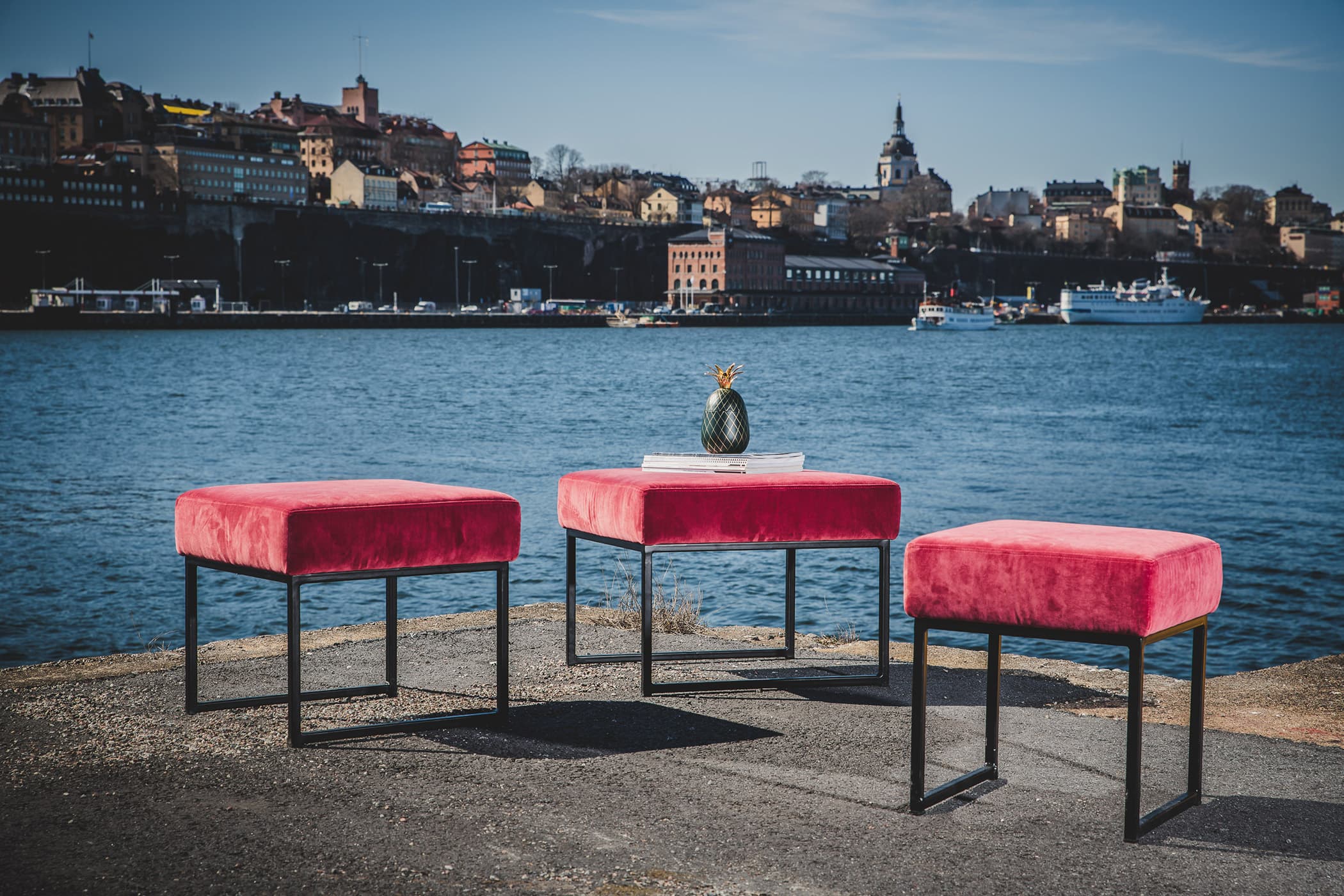 Liten, rosa sammetsklädd pall med svart stålunderrede i ca 40cm/50cm/60cm i bredd.