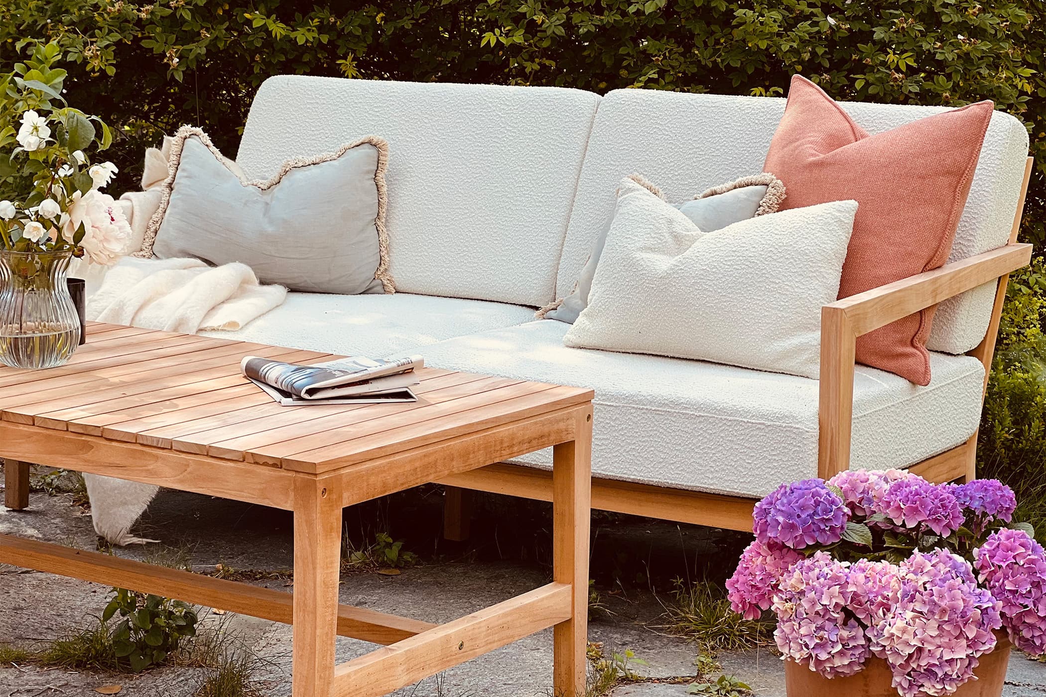 Mjuk, dunfri utomhussoffa med teakstomme och tåligt utomhustyg med avtagbar klädsel. Utomhusbord i teak, 70x140cm stort.